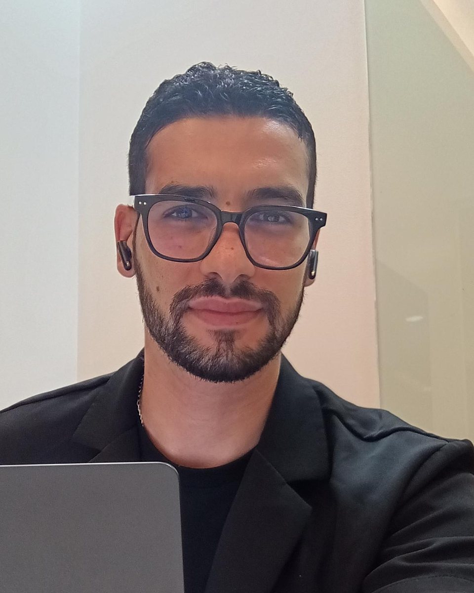 Ben A. Wajdi, in glasses and a black jacket, smiling at the camera